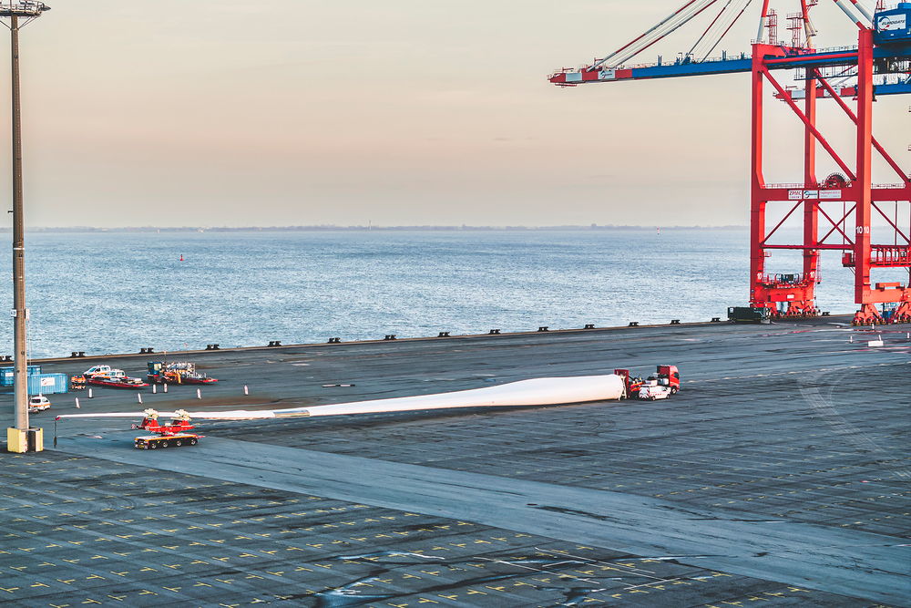 Schwertransportfahrzeug von DOLL für Windkraftanlagen am Hafen bei Sonnenuntergang